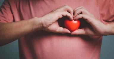 händer innehav och ger röd hjärta för kärlek, hälsa vård, organ donation, värld hjärta dag, värld hälsa dag, mindfulness, väl varelse, familj försäkring begrepp. foto