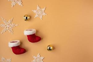 handgjort virka strumpa och vit snöflinga på orange pastell bakgrund. glad jul och Lycklig ny år begrepp. foto