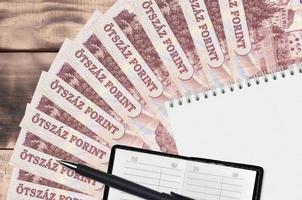 500 ungerska forint räkningar fläkt och anteckningsblock med Kontakt bok och svart penna. begrepp av finansiell planera och företag strategi foto