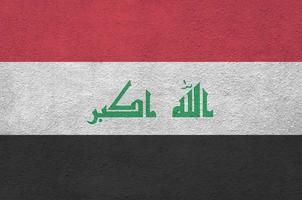 irak flagga avbildad i ljus måla färger på gammal lättnad putsning vägg. texturerad baner på grov bakgrund foto