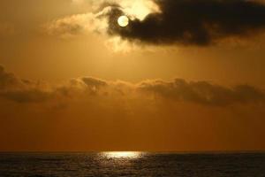 solen går ner under horisonten på Medelhavet i norra Israel. foto