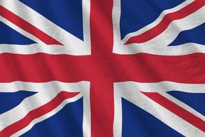 bra storbritannien flagga med stor veck vinka stänga upp under de studio ljus inomhus. de officiell symboler och färger i baner foto