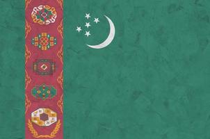 turkmenistan flagga avbildad i ljus måla färger på gammal lättnad putsning vägg. texturerad baner på grov bakgrund foto