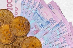 200 ukrainska hryvnias räkningar och gyllene bitcoins. kryptovaluta investering begrepp. crypto brytning eller handel foto