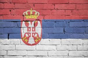 serbia flagga är målad till ett gammal tegel vägg foto