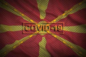 macedonia flagga och covid-19 stämpel med orange karantän gräns tejp korsa. coronavirus eller 2019-ncov virus begrepp foto