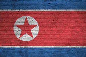 norr korea flagga avbildad i måla färger på gammal tegel vägg. texturerad baner på stor tegel vägg murverk bakgrund foto