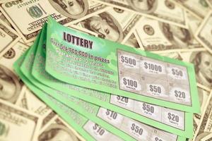 stänga upp se av grön lotteri repa kort och oss dollar räkningar. många Begagnade falsk omedelbar lotteri biljetter med hasardspel resultat. hasardspel missbruk foto