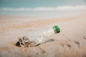 miljö, ekologi vård, förnybar begrepp. plast flaska avfall på de strand sand foto