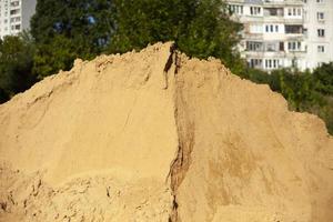 kulle av sand på konstruktion webbplats. byggnad material för fundament. gul sand. foto