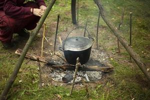 panna på brand. matlagning i skogen. turist bål med pinnar. foto
