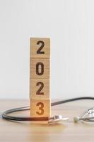 2023 Lycklig ny år för hälsa vård, försäkring, wellness och medicinsk begrepp. stetoskop av läkare på tabell foto