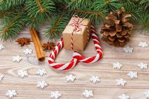 jul bakgrund med jul träd grenar, tall kottar, godis sockerrör sötsaker, gåvor, snöflinga och dekorationer, kopia Plats foto