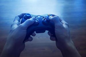 video spel kontrollant i mänsklig händer, i främre av de TV foto