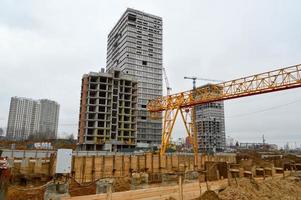 hög tung gul metall järn bärande konstruktion stationär industriell kraftfull brygga kran av bro typ på stöder för lyft frakt på en modern konstruktion webbplats av byggnader och hus foto