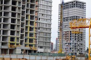 stor betong cement modern under konstruktion ny modern monolitisk ram-block hus byggnad med fönster, väggar och balkonger foto