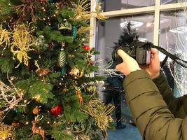 jul dekorationer på de träd. volumetriska leksaker i de form av en boll. glas, omfattande leksaker hänga på de träd. jul dekoration. fotograf tar bilder av Smycken på kamera foto