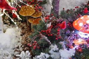 jul dekor för en handla Centrum. söt amanita svamp med lampor inuti. Nästa till dem är röd fåglar tillverkad av artificiell material. en jul krans är tillverkad från rönn foto