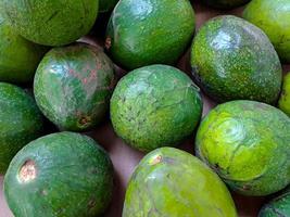 knippa av grön avokado på de lokal- frukt marknadsföra. friska och utsökt färsk frukt. detta frukt är ofta Begagnade i juicer foto