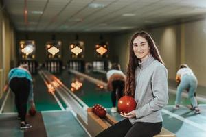 ung kvinna har roligt i en bowling gränd foto