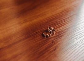 två bröllop ringar på de golv med kontrast foto