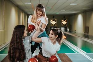 tre kvinna vänner har roligt och bowling tillsammans foto