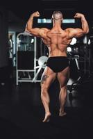 kondition man som visar hans muskler på de Gym foto