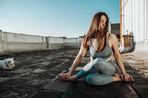 kvinna håller på med yoga utomhus på en taket terrass foto