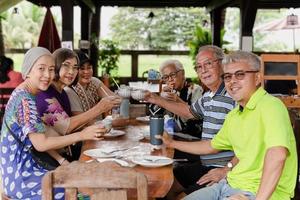 grupp av Lycklig familj har lunch och framställning en toasting på restaurang. foto