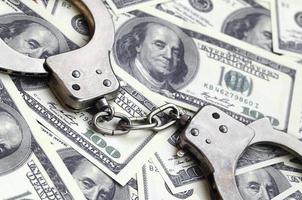 polis handklovar lögn på en massa av dollar räkningar. de begrepp av olaglig besittning av pengar, olaglig transaktioner med oss dollar. ekonomisk brottslighet foto