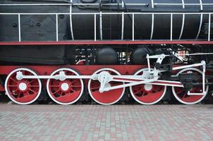 hjul av de gammal svart ånga lokomotiv av sovjet gånger. de sida av de lokomotiv med element av de roterande teknologi av gammal tåg foto