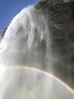 en regnbåge i främre av Seljalandsfoss vattenfall på de sydlig kust av island på en solig dag foto