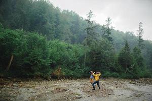 lekfull Lycklig stilig par har medan gående i skogen. turister i de berg. äventyr i natur begrepp. par i de bergen foto