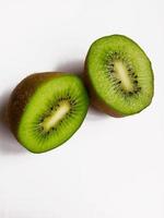 två halvor av mogen färsk kiwi på vit bakgrund foto