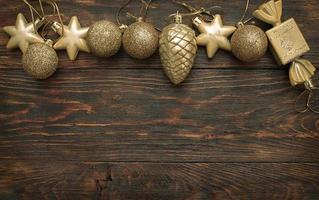 guld jul bollar och leksaker på en trä- bakgrund foto