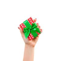 kvinna händer ge insvept jul eller Övrig Semester handgjort närvarande i röd papper med grön band. isolerat på vit bakgrund, topp se. tacksägelse gåva låda begrepp foto