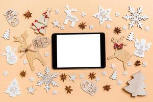 festlig dekorationer och leksaker på orange bakgrund. topp se av digital läsplatta. glad jul begrepp foto