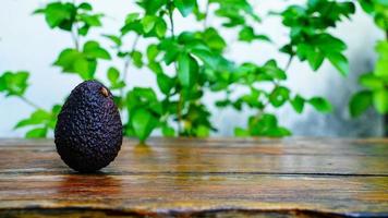 färsk grön avokado på en trä- tabell är en mycket användbar och vitamin frukt. foto
