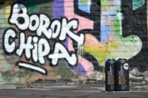 kharkov. ukraina - Maj 17, 2022 Begagnade montana svart aerosol spray burkar mot graffiti målningar. mtn eller montana-burkar är tillverkare av hög tryck spray måla varor foto