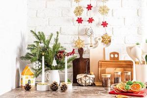 skön interiör del av de modern kök dekorerad för de ny år och jul. gran bukett, kottar, handgjort krans på en vit tegel vägg. foto