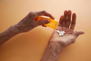 topp se av senior kvinnor tar piller på orange bakgrund foto