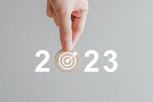 2023 ny år utmaning mål och mål, prestation, företag Framgång. uppsättning strategi och planen för framtida. hand innehav 2023 med darttavla. bakgrund för glad jul och Lycklig ny år 2023. foto