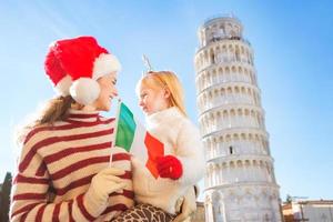 mor och dotter som håller italiensk flagga. jul i pisa