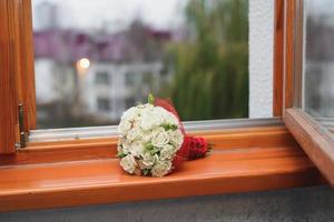 de brudens bröllop bukett av vit ro lögner på de fönsterkarm foto