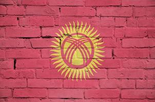 kyrgyzstan flagga är målad till ett gammal tegel vägg foto