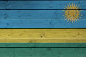 rwanda flagga avbildad i ljus måla färger på gammal trä- vägg. texturerad baner på grov bakgrund foto