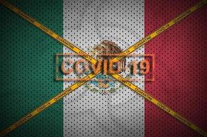 mexico flagga och covid-19 stämpel med orange karantän gräns tejp korsa. coronavirus eller 2019-ncov virus begrepp foto