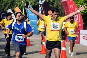 ny delhi, Indien - oktober 16 2022 - vedanta delhi halv maraton lopp efter covid i som maraton deltagarna handla om till korsa de Avsluta linje, delhi halv maraton 2022 foto