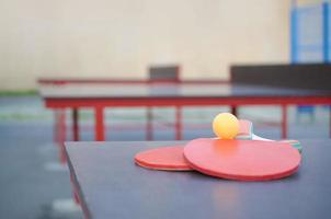 racketar och boll på ping pong tabell i utomhus- sport gård. aktiva sporter och fysisk Träning begrepp foto