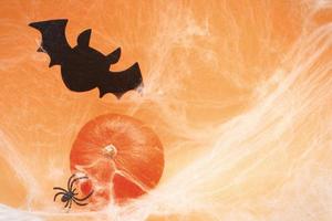 halloween pumpa med Spindel webb, fladdermus och svart spindlar på orange bakgrund. foto